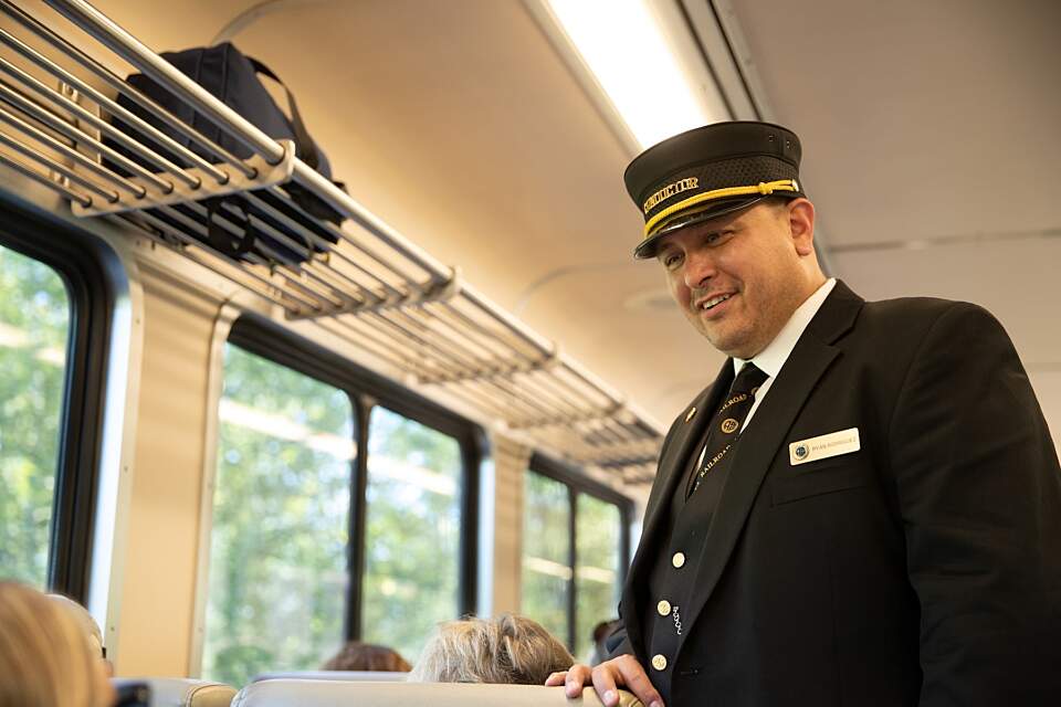 A conducter engages with passengers aboard The Alaska Railroad